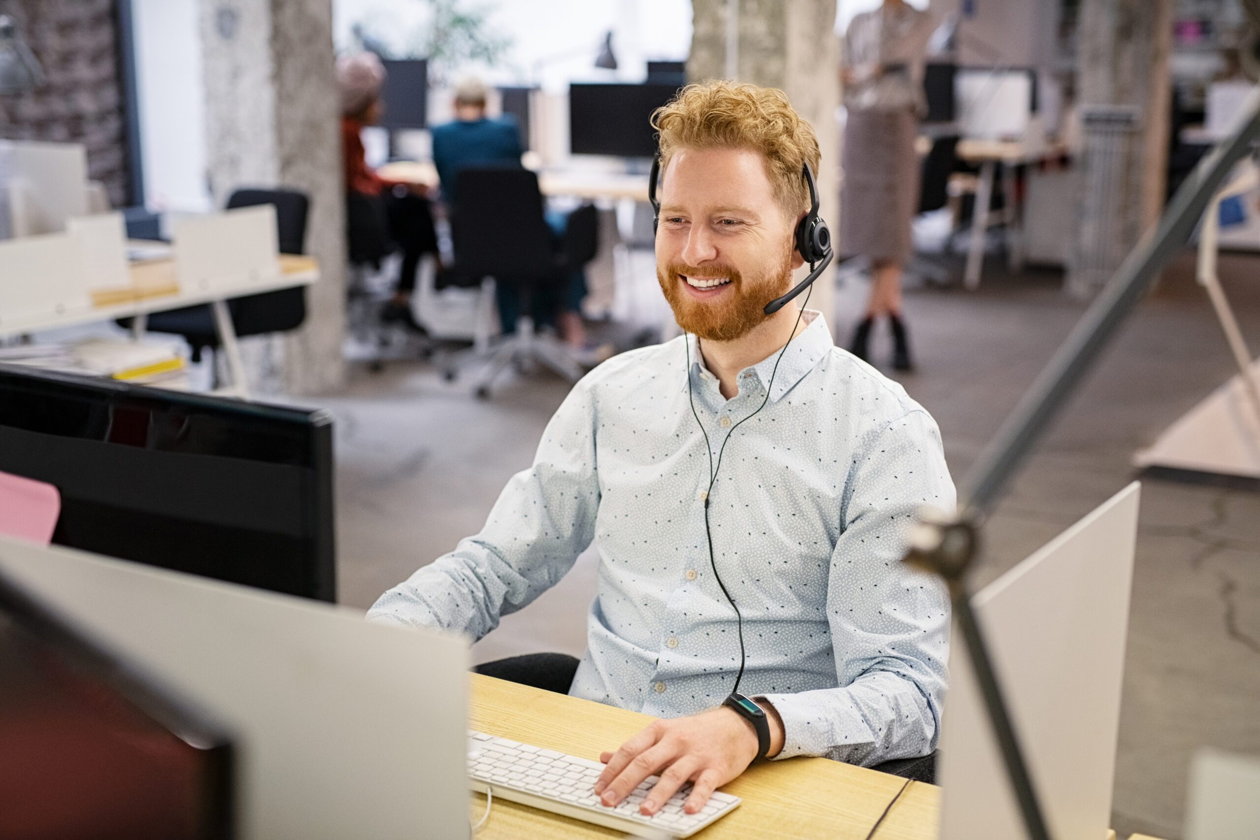 Man with headset on a call with customer.